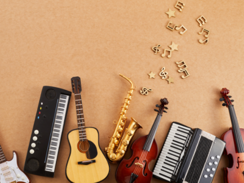 Flatlay mit Instrumenten wie Gitarre und Keyboard sowie Notenschlüsseln.