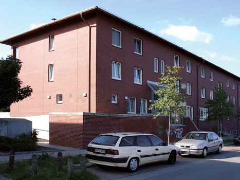 mehrstöckiges modernes Backsteinhaus mit Fenstern zur Straßenseite