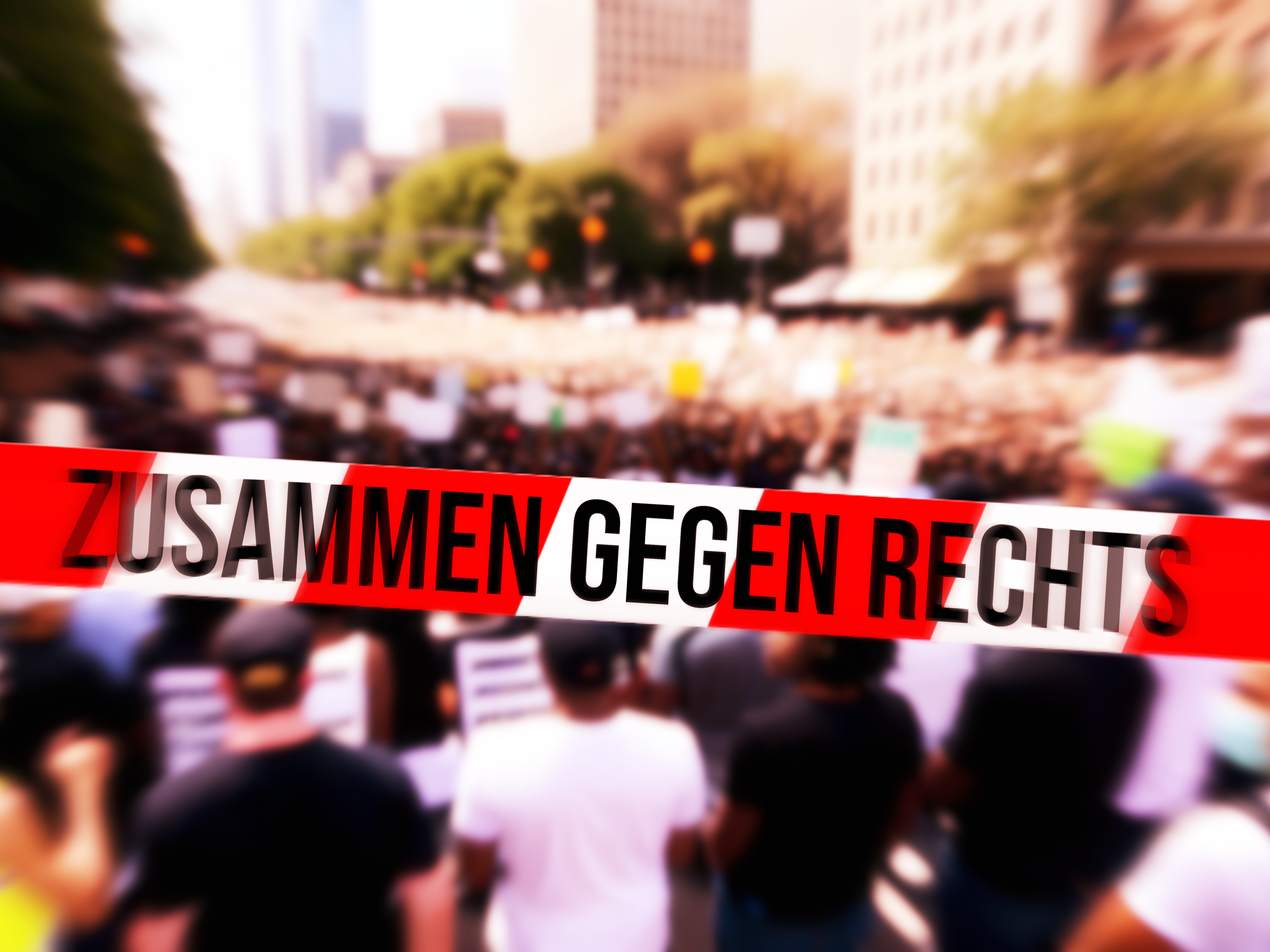 Flatterband mit Aufschrift: Gegen Rechts, im Hintergrund demonstrierende Menschen