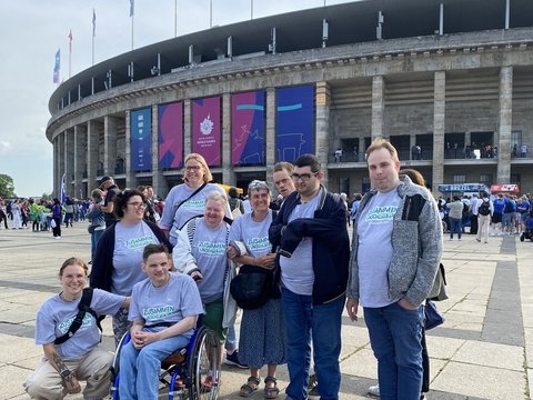 Eine Grupppe von Menschen mit und ohne Rollstuhl vor dem Olympiastadion in Berlin.