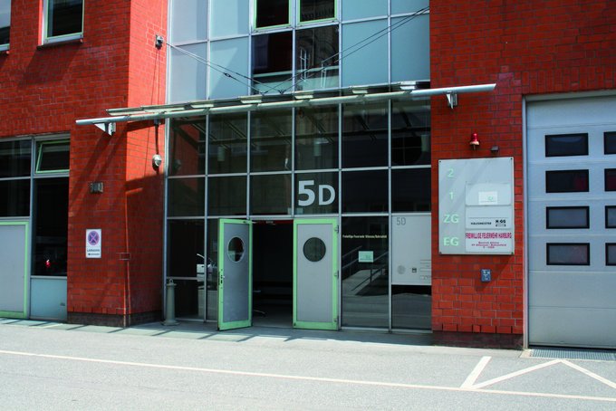 Eingang eines roten Backsteingebäudes mit Glasfront