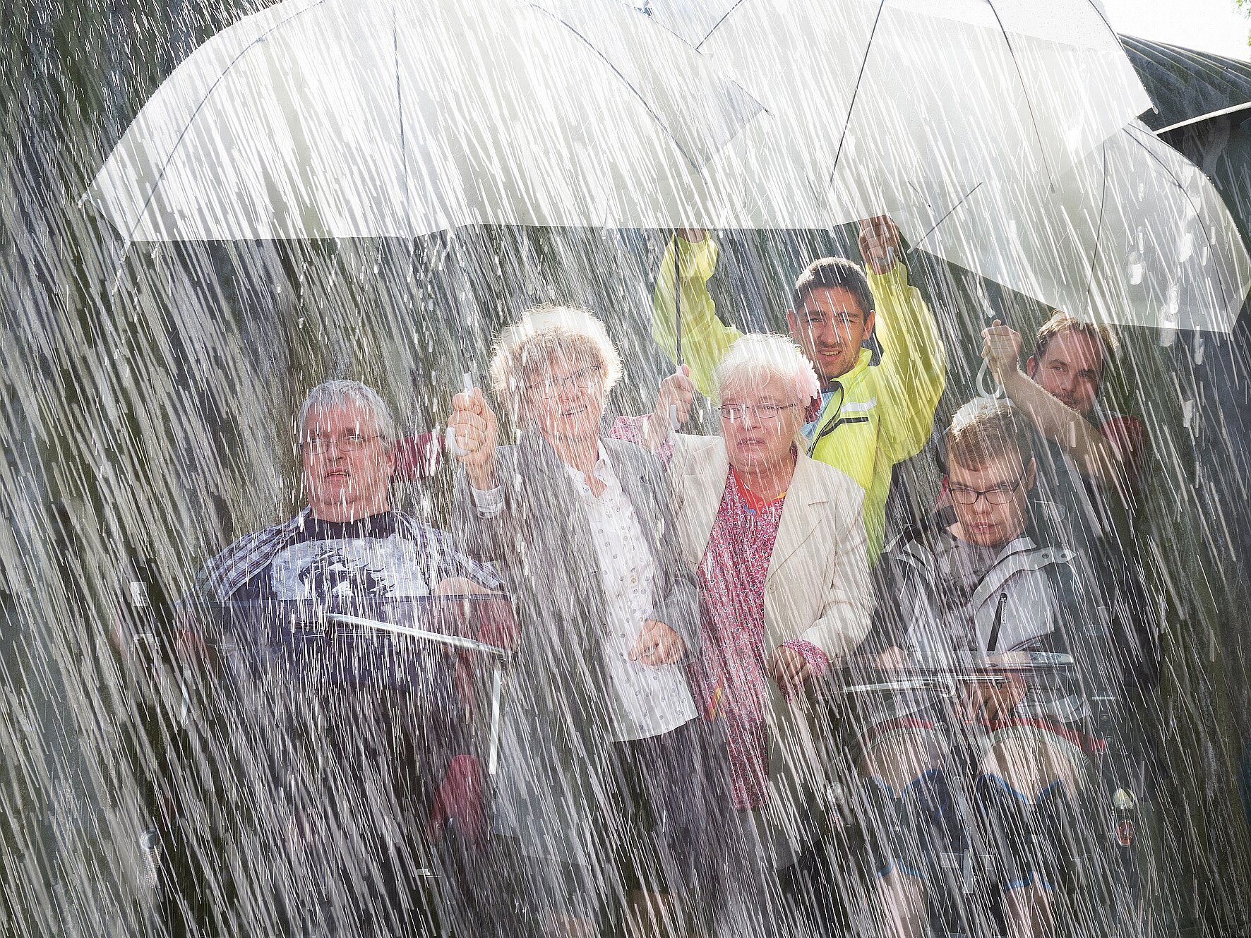 Menschengruppe unter einem Regenschirm