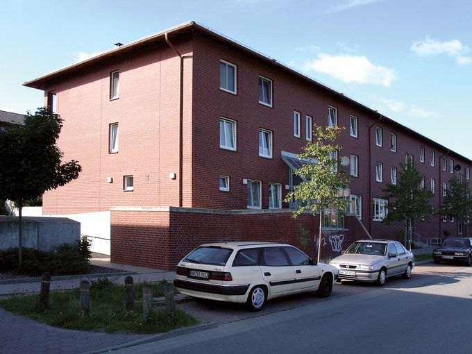 mehrstöckiges modernes Backsteinhaus mit Fenstern zur Straßenseite
