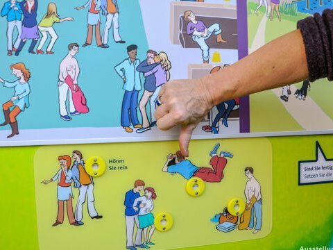 Hand vor einer Ausstellungstafel