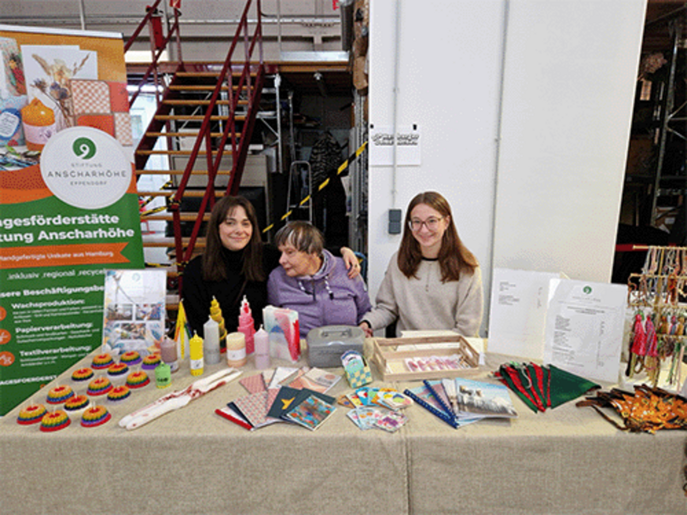 Ein Stand der Stiftung Anschar Höhe mit drei Frauen und den Produkten