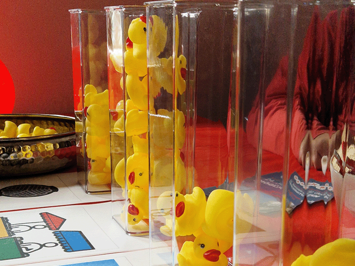 NAHT-Markt im Brakula: Stand mit Gummienten in Glassäulen und Piktogramme für Unterstützte Kommunikation