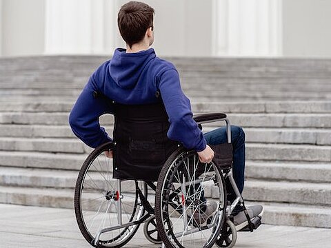 Rollstuhlfahrer vor Treppe