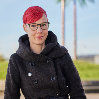 Ein Foto von Monika Bauer. Im Hintergrund sieht man den Hamburger Park Fiction.