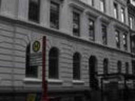 Mehrstöckiges Gebäude mit klassischer Fassade und mehreren Fenstern in einer städtischen Straße