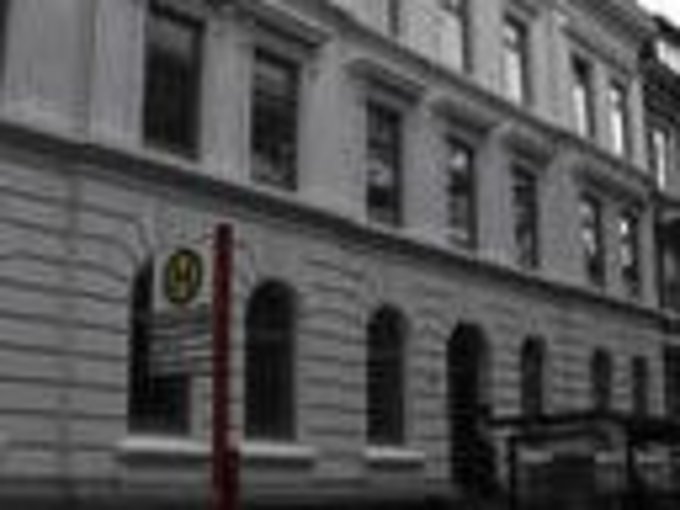 Mehrstöckiges Gebäude mit klassischer Fassade und mehreren Fenstern in einer städtischen Straße