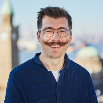 Ein Foto von Enrico Seligmann. Im Hintergrund sieht man den Hamburger Hafen.