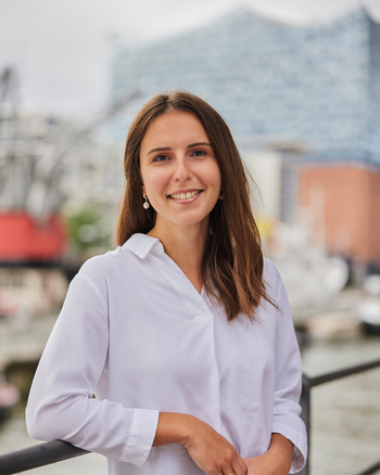 Ein Foto von Rebeka Lenz. Im Hintergrund sieht man die Hamburger Elbphilharmonie.