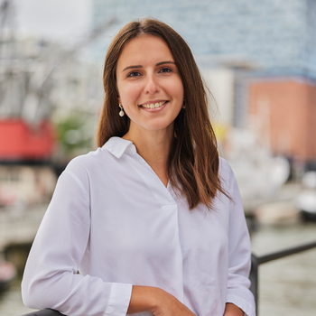 Ein Foto von Rebeka Lenz. Im Hintergrund sieht man die Hamburger Elbphilharmonie.
