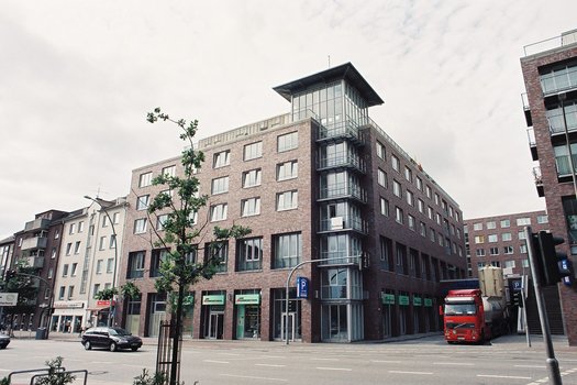 Straßenecke mit mehrstöckigem Gebäude aus Backstein und Glas