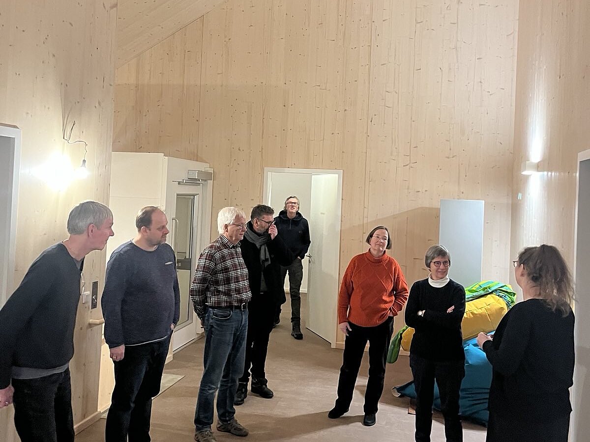 Eine Gruppe Menschen sieht sich ein Gebäude von innen an.