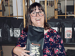 Eine Frau hält ein Paket Kaffee in der Kaffeerösterei