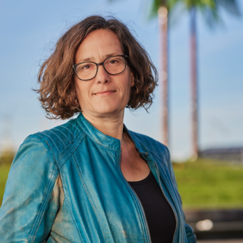 Astrid Lindemann steht vor künstlichen Palmen und lächelt