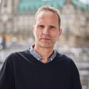 Ein Foto von Frank Nestler. Im Hintergrund sieht man das Hamburger Rathaus